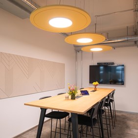 Iluminación acústica en la sala de reuniones de la oficina para crear un ambiente agradable y reducir el ruido de fondo, ideal para reuniones de pie.