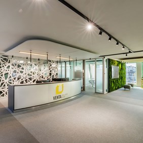 Solução de iluminação elegante para a área da receção com o sistema de calhas HYPRO preto e projectores flexíveis montados à superfície.