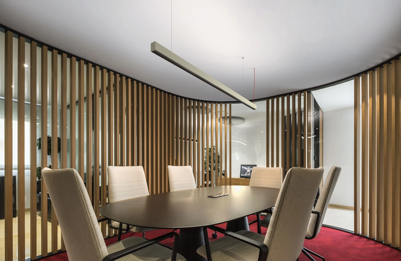 Representación de una luminaria suspendida con lente Batwing en una sala de reuniones: iluminación indirecta para techos bajos. (Representación)
