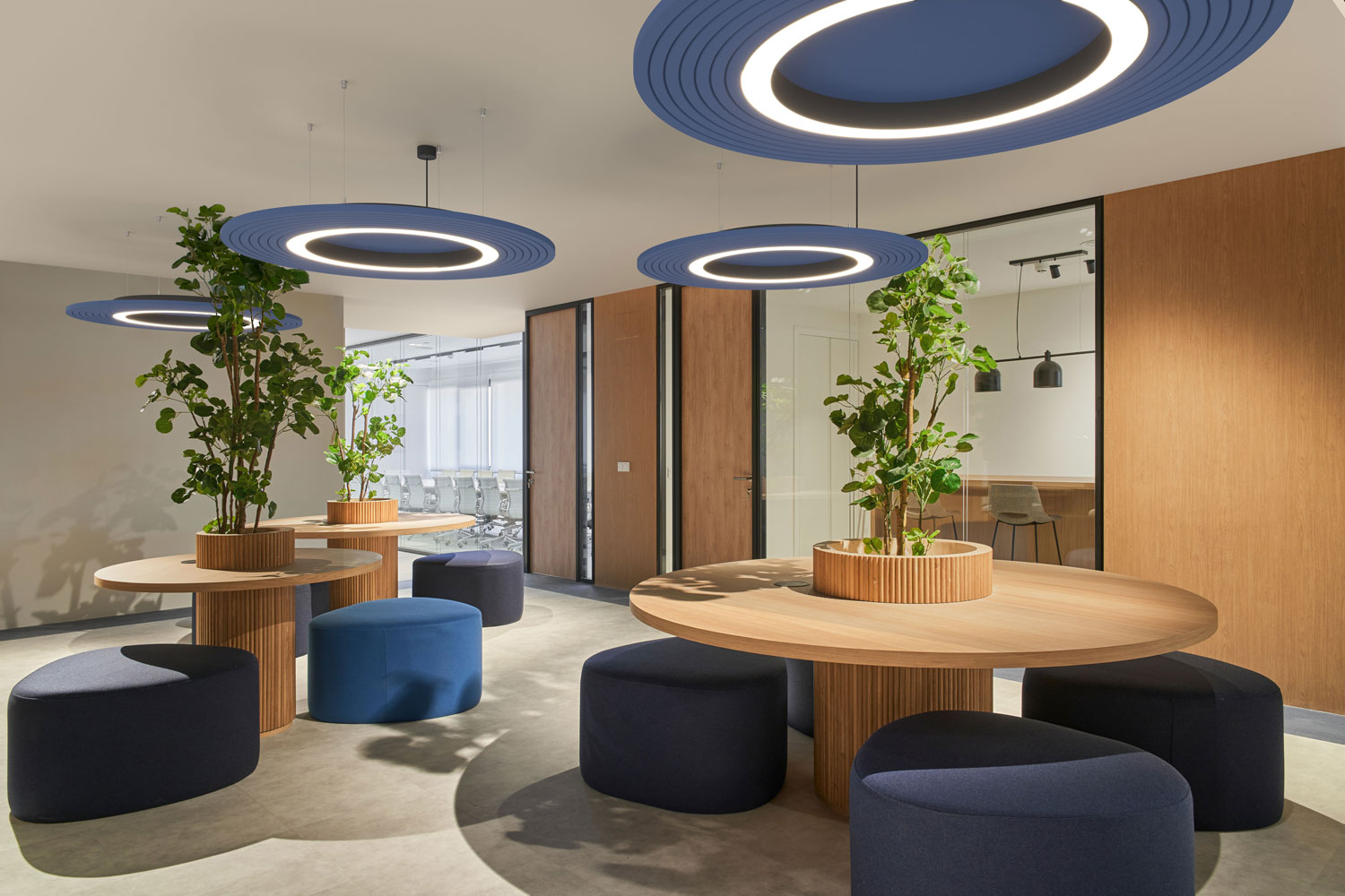 Candeeiro acústico azul, redondo e plano num espaço de escritório partilhado.