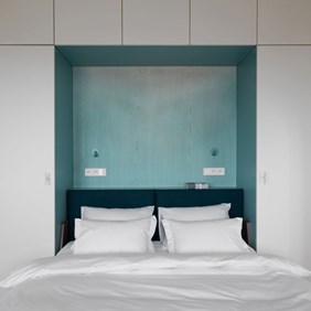 Flexible bedroom lighting with blue, swivelling Imagine spotlights as a night light solution above the bed