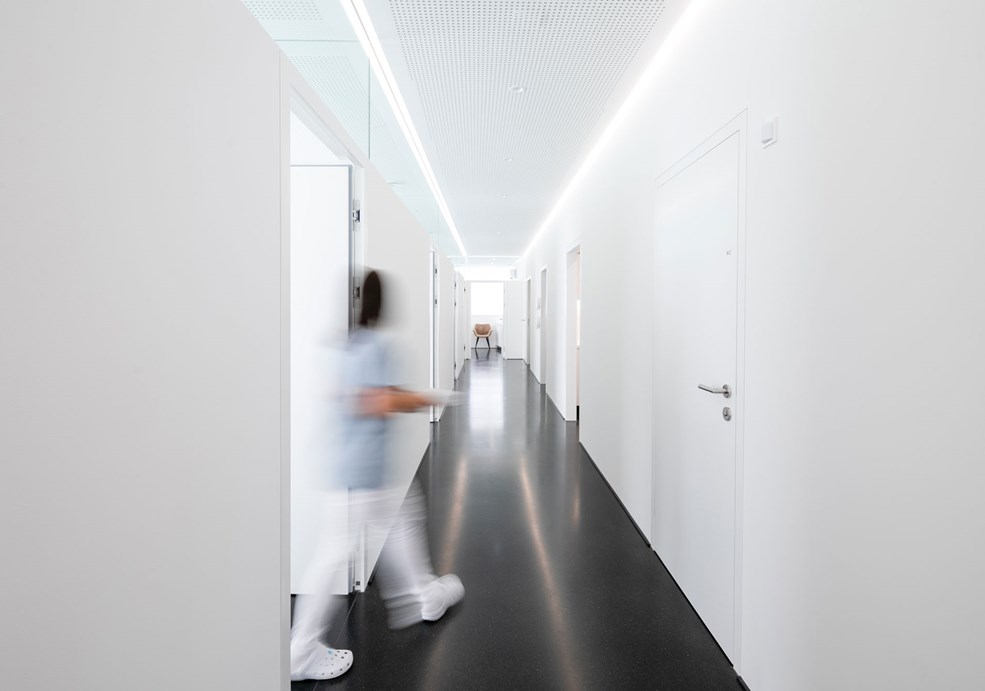 The modern lighting in the hallway of a dental practice integrates a guidance system that offers patients orientation through targeted lighting.