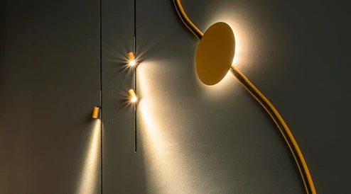 Calha Minimal em dourado com várias inserções, tais como spots e projectores indirectos de superfície.