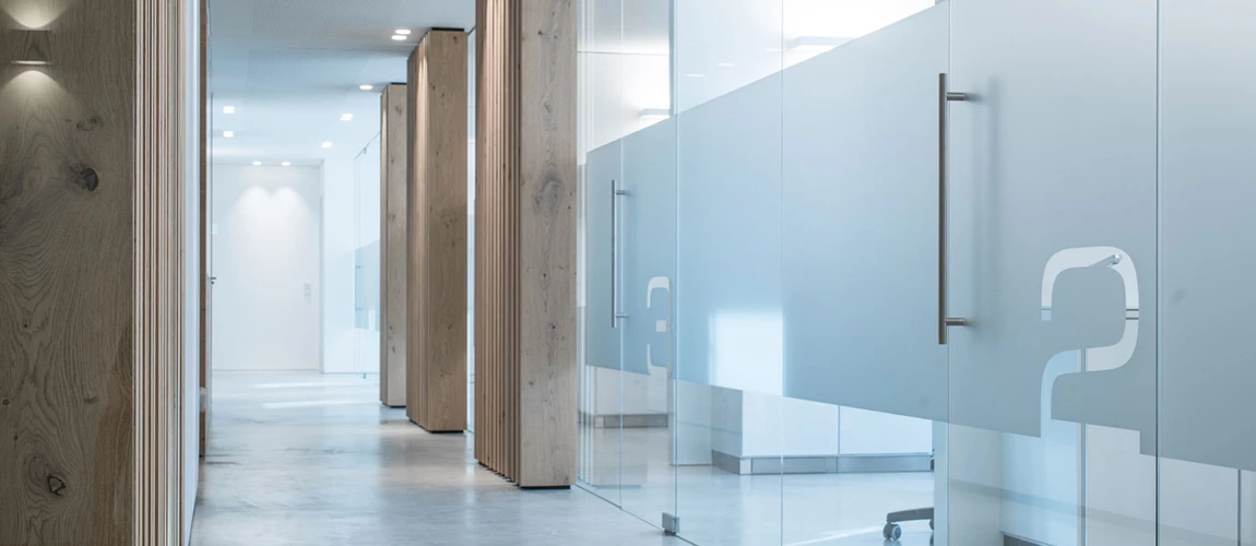 Discreet downlights, flush-mounted in the ceiling, provide uniform illumination in the hallway of a doctor's office.