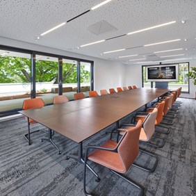Sala de reuniones con sistema de perfiles Hypro 40. El sistema cuenta con tiras LED convencionales como inserciones y focos Oiko Pro In flexibles y giratorios para la iluminación dirigida de diferentes áreas.