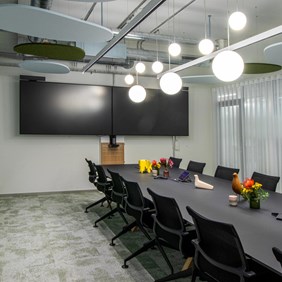 Paneles acústicos Prolicht en combinación con lámparas colgantes esféricas redondas en la sala de reuniones.