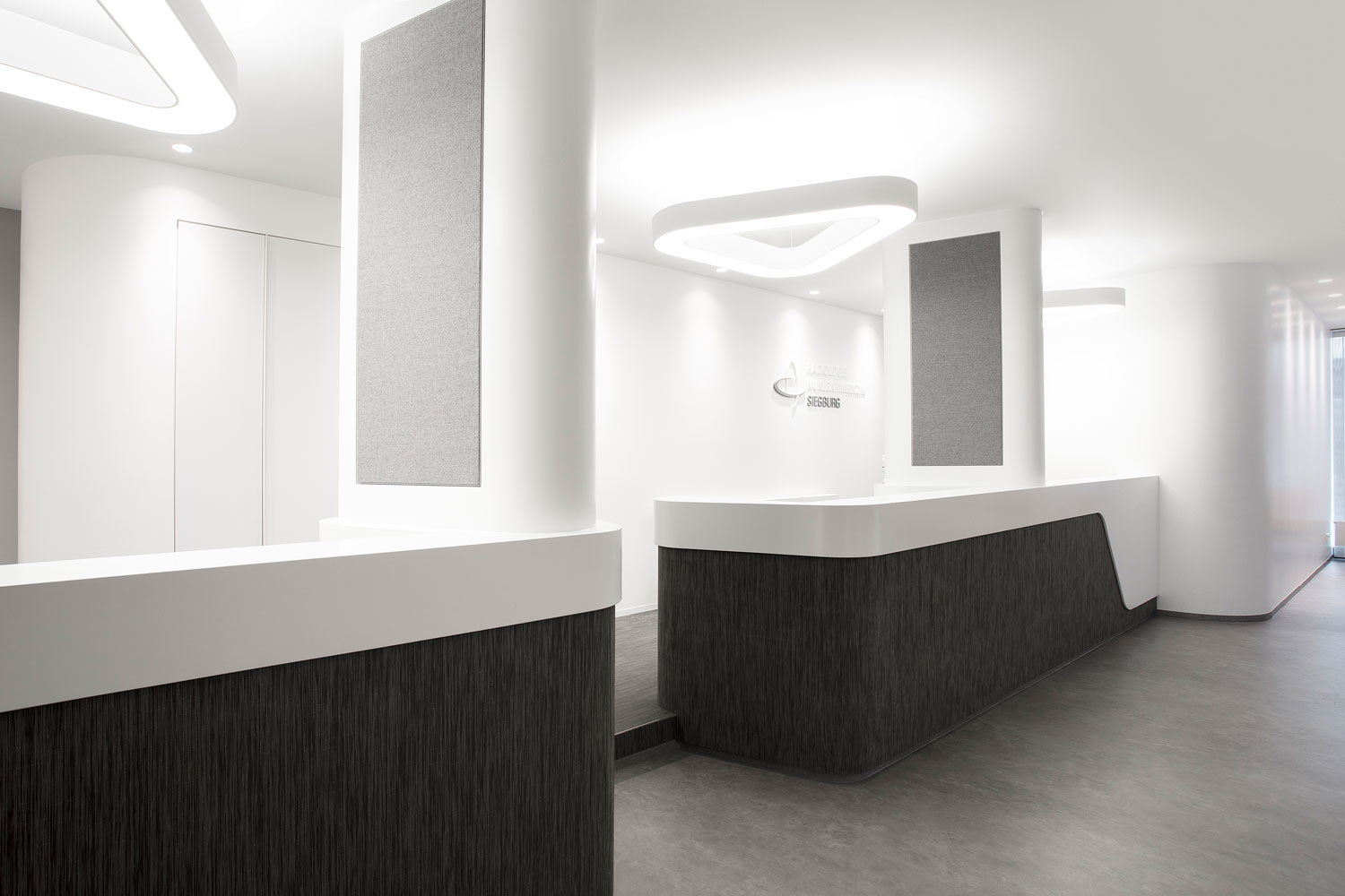 Una llamativa lámpara colgante triangular aporta un toque de estilo y proporciona una iluminación específica de la zona de recepción.