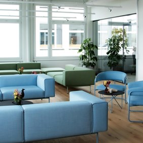 Sala de estar de oficina moderna con iluminación elegante para crear un ambiente acogedor. Sistema de perfil HYPRO blanco con luminarias focales.